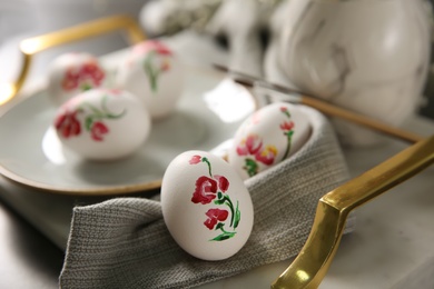 Photo of Beautifully painted Easter egg on tray, closeup