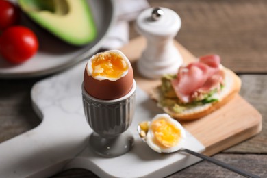 Soft boiled chicken egg served on wooden table