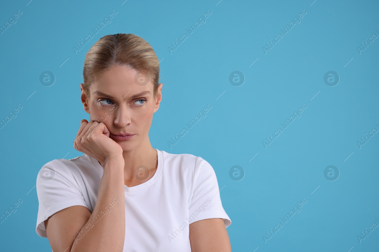 Photo of Resentful woman on light blue background. Space for text