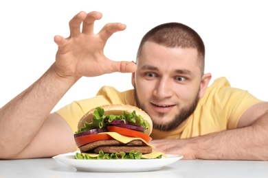 Photo of Young man and tasty burger on white background