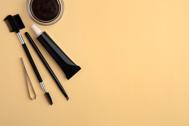 Photo of Flat lay composition with eyebrow henna and tools on beige background. Space for text