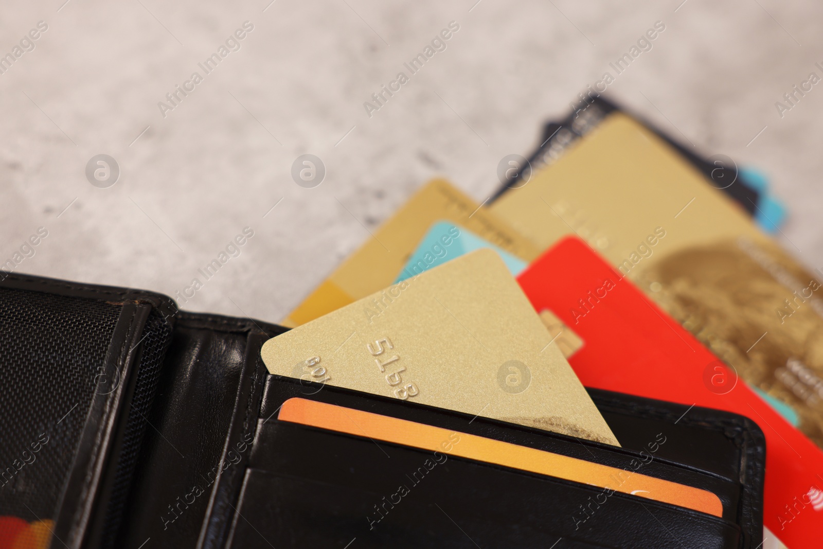 Photo of Many different credit cards and leather wallet on grey table, closeup