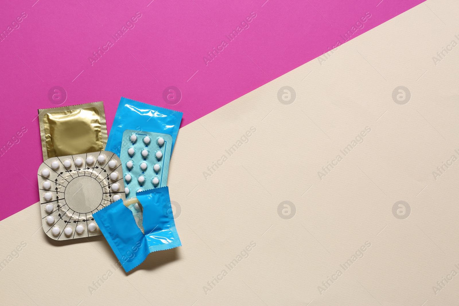 Photo of Contraceptive pills and condoms on color background, flat lay with space for text. Different birth control methods