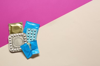 Contraceptive pills and condoms on color background, flat lay with space for text. Different birth control methods