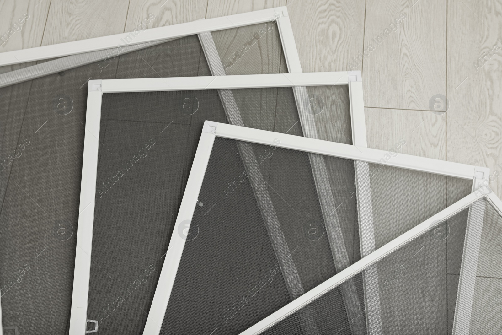 Photo of Set of window screens on wooden floor, flat lay