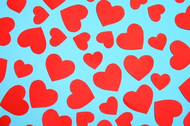 Small paper hearts on color background, top view