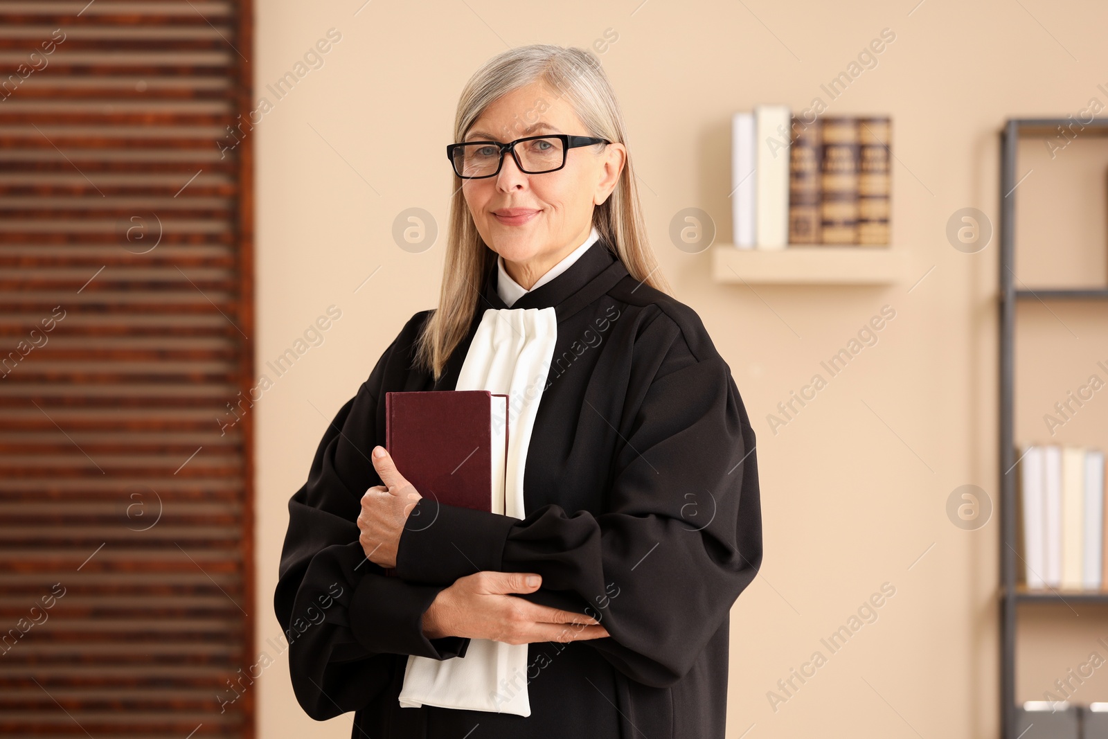 Photo of Portrait of judge in court dress with book indoors