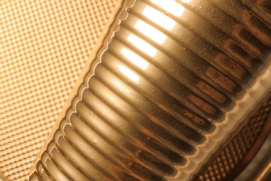 Golden cup on blurred background, closeup view