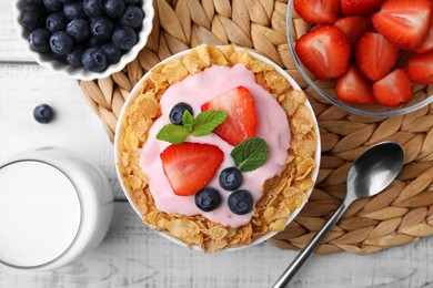 Photo of Delicious crispy cornflakes, yogurt and fresh berries served on white wooden table, flat lay. Healthy breakfast
