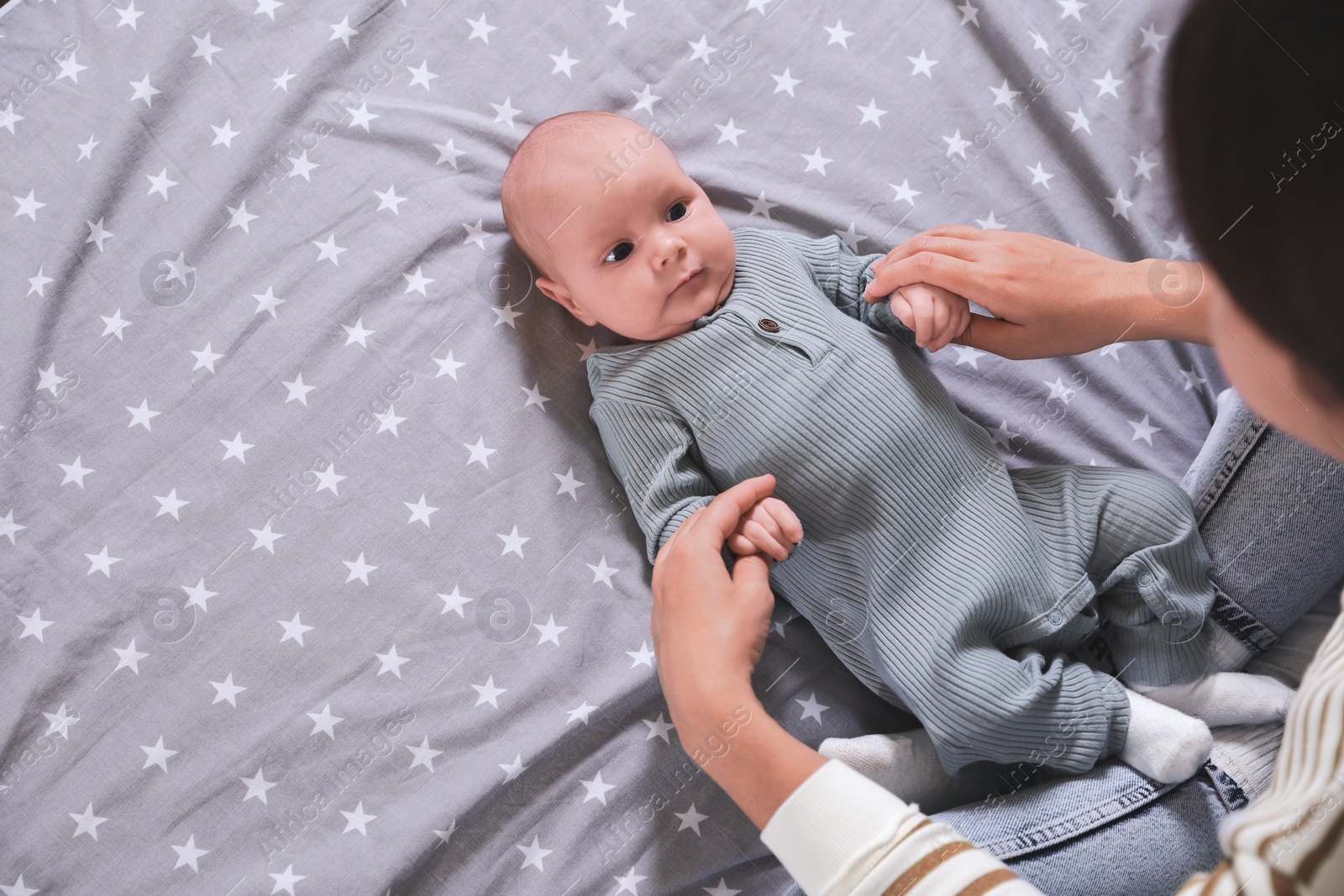 Photo of Mother and her little baby on bed, above view. Space for text