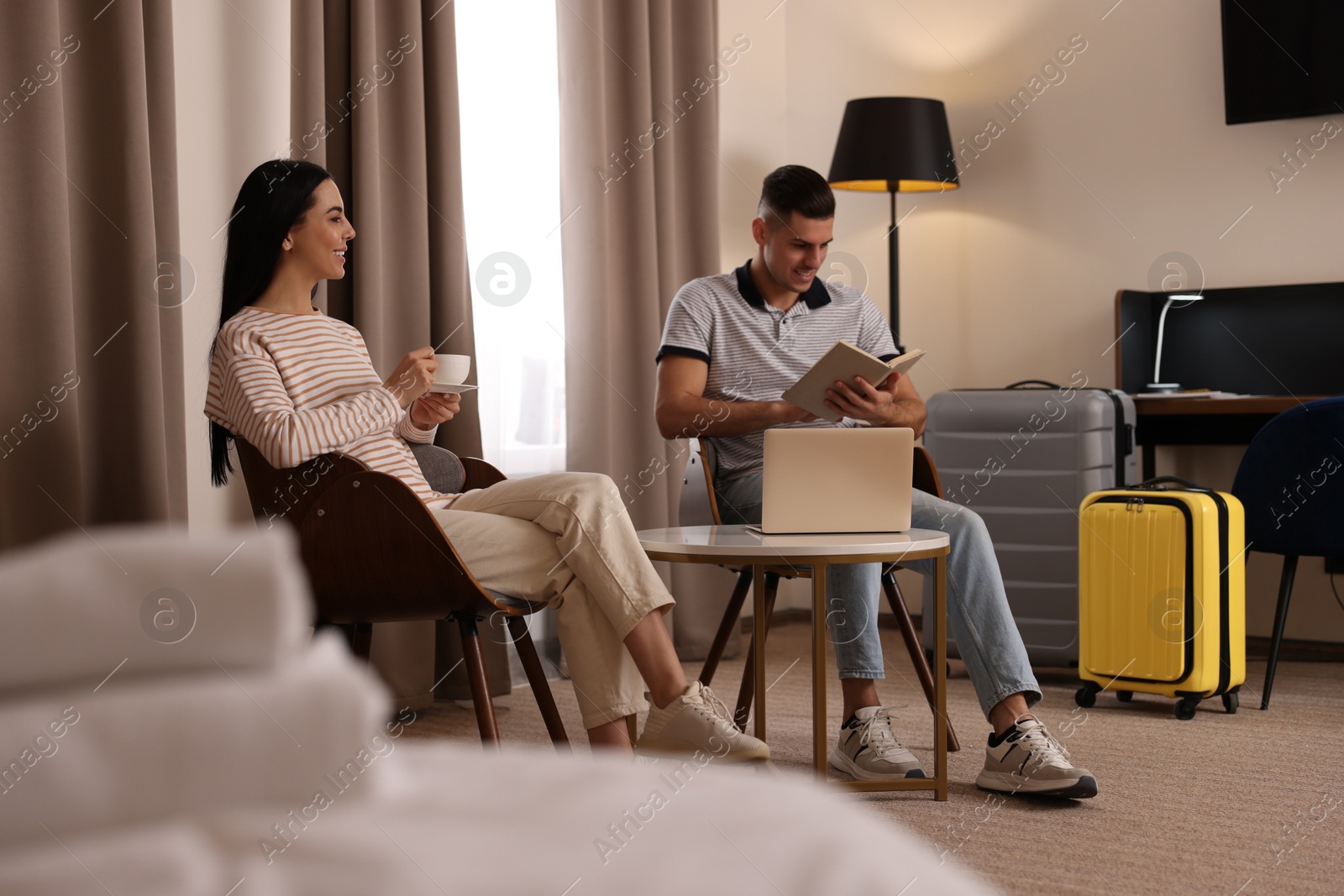 Photo of Happy couple spending time together in hotel room