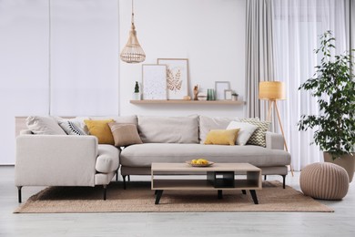 Stylish living room interior with comfortable grey sofa and coffee table