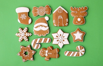 Different Christmas gingerbread cookies on green background, flat lay