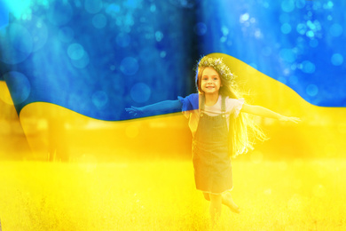 Double exposure of adoracble little girl with flower wreath running outdoors and Ukrainian flag 