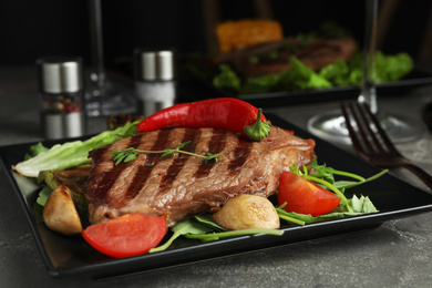 Delicious beef steak served on grey table, closeup