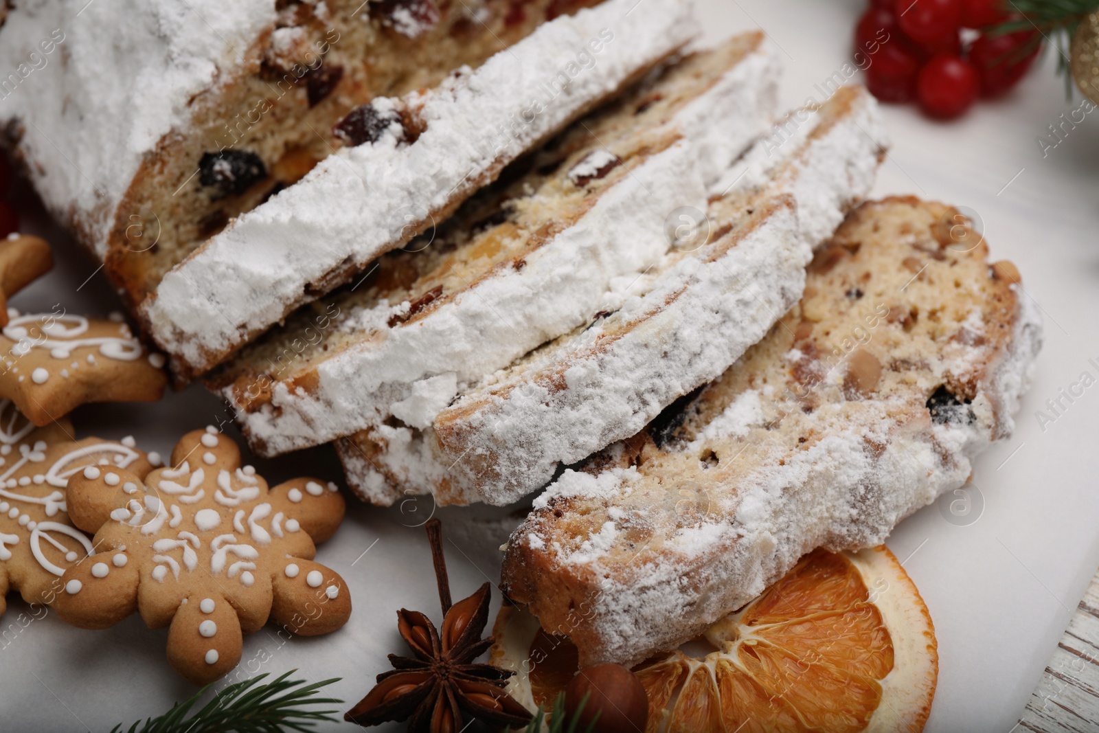 Photo of Traditional Christmas Stollen with icing sugar on white board, closeup