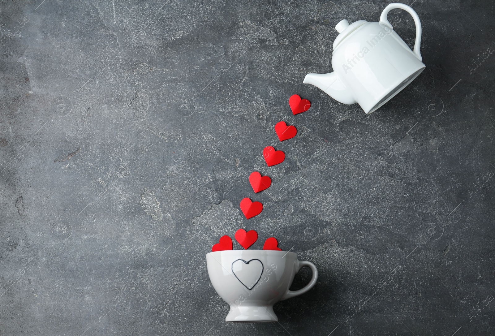 Photo of Flat lay composition with teapot, cup and red paper hearts on grey background