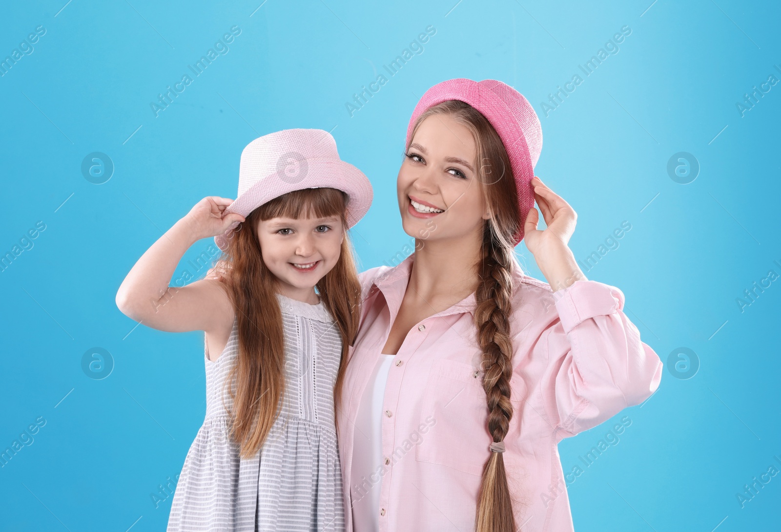 Photo of Happy woman and daughter in stylish clothes on color background