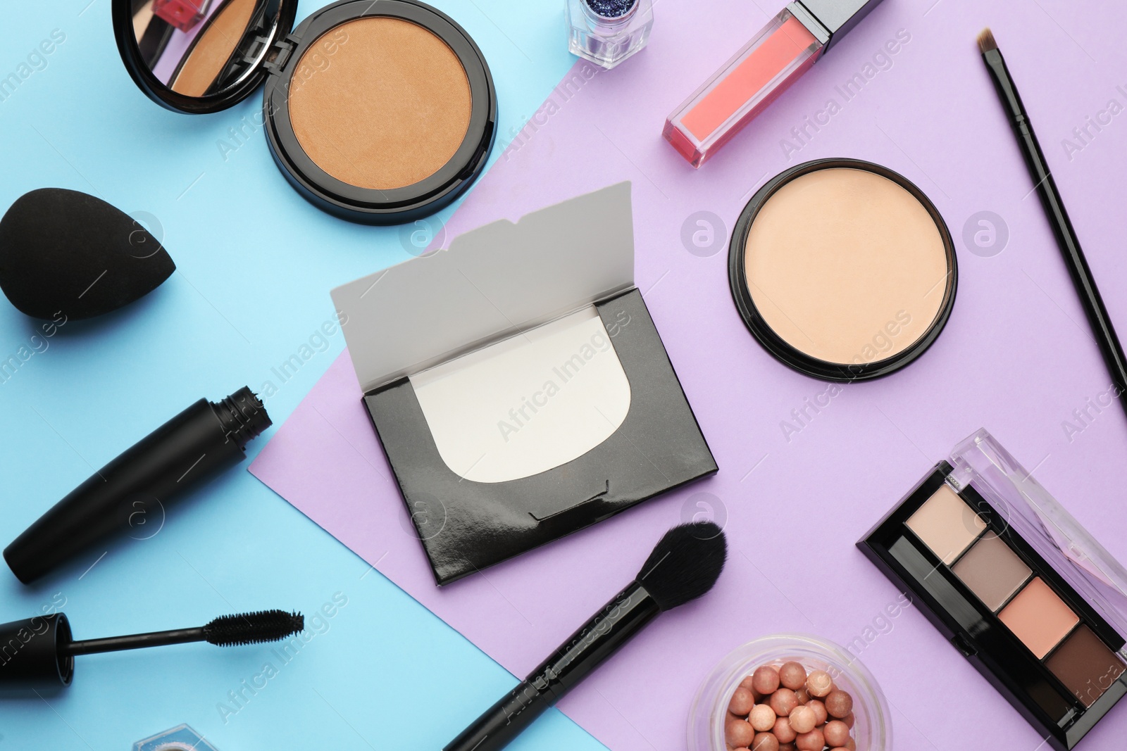 Photo of Flat lay composition with facial oil blotting tissues and makeup products on color background. Mattifying wipes