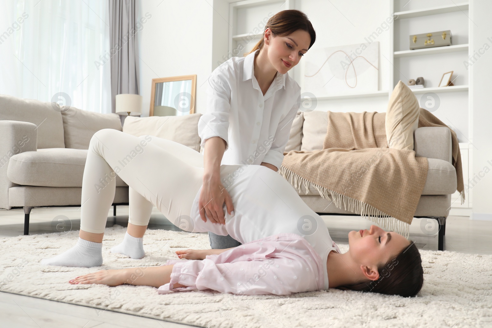 Photo of Doula working with pregnant woman at home. Preparation for child birth