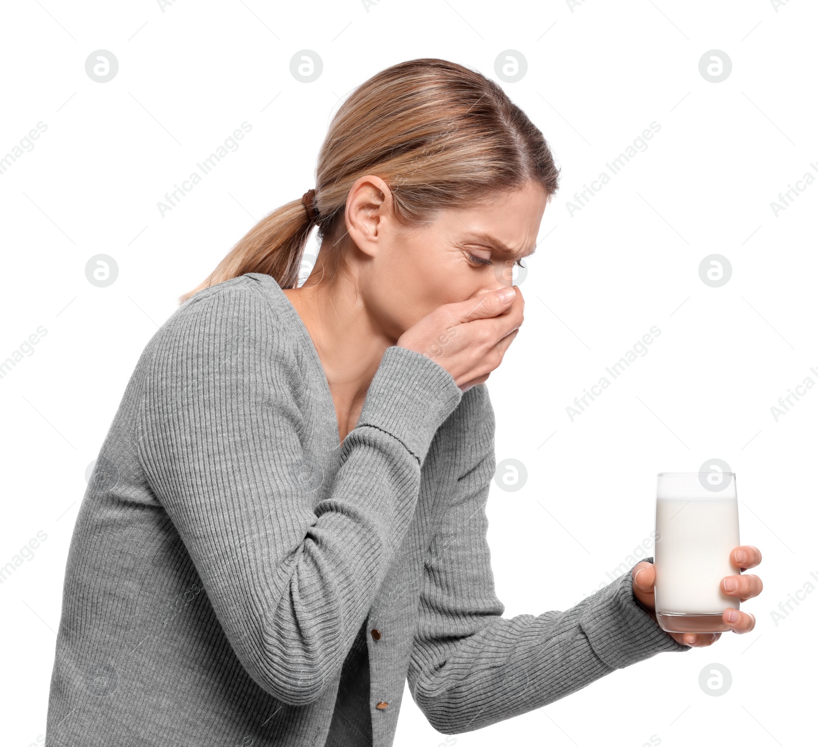 Photo of Woman with glass of milk suffering from lactose intolerance on white background