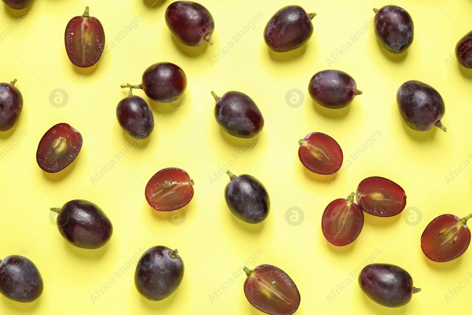 Photo of Flat lay composition with fresh ripe juicy grapes on yellow background