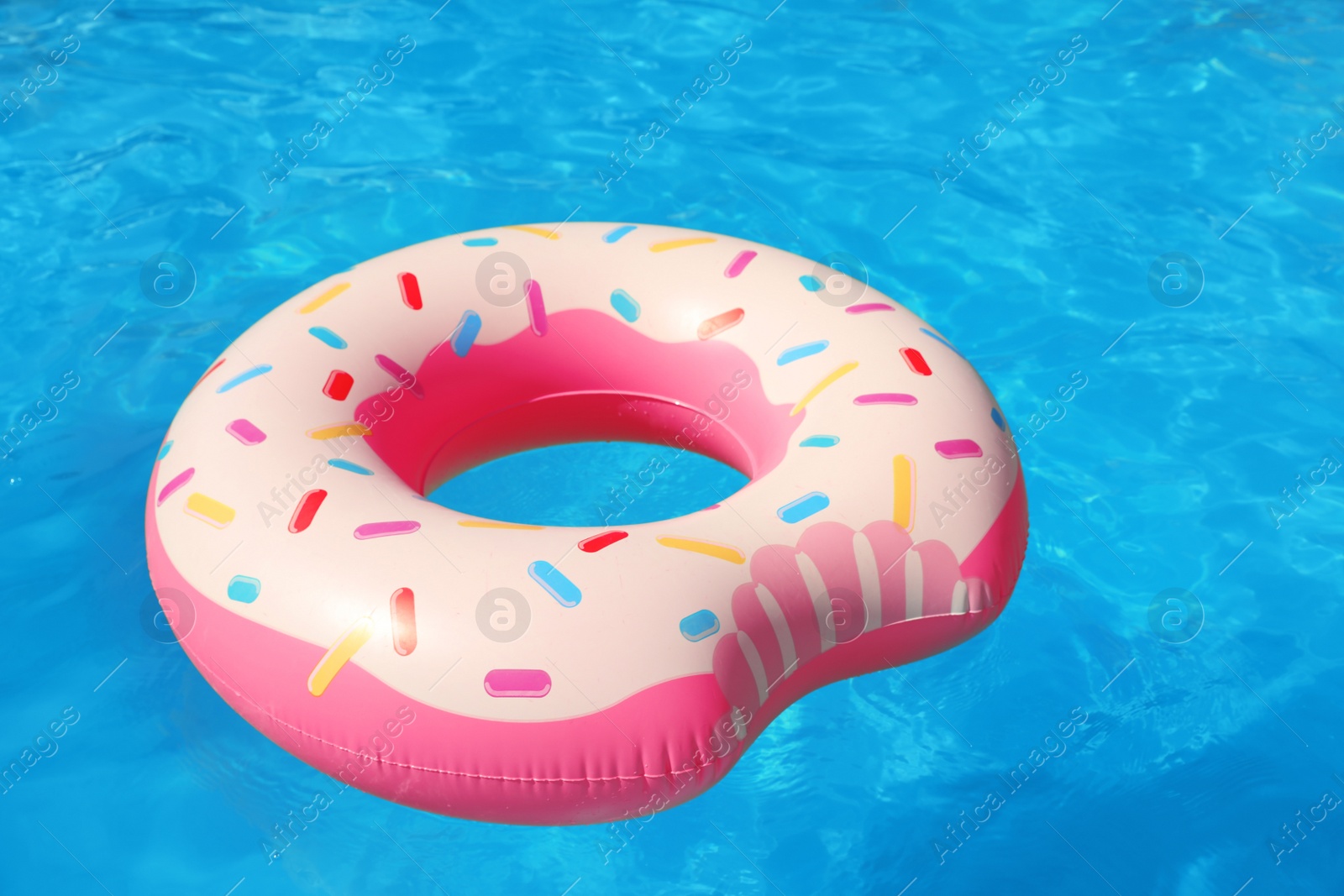 Photo of Inflatable ring floating in swimming pool on sunny day