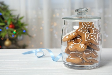 Photo of Glass jar with tasty homemade Christmas cookies on table