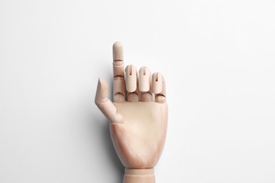 Wooden mannequin hand on white background, top view