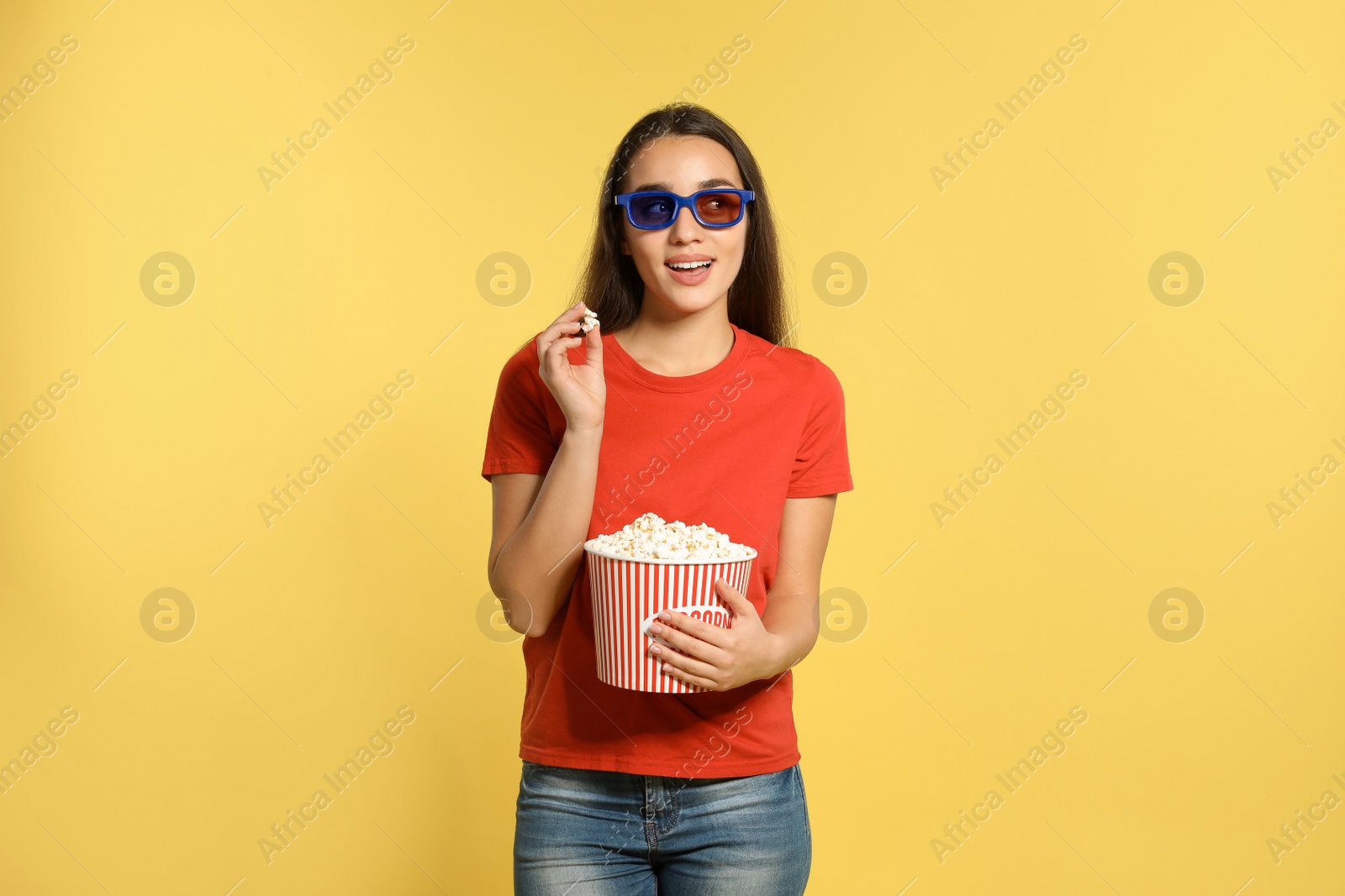 Photo of Woman with 3D glasses and popcorn during cinema show on color background