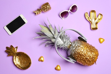 Photo of Flat lay composition with pineapple, smartphone, sunglasses and headphones on color background
