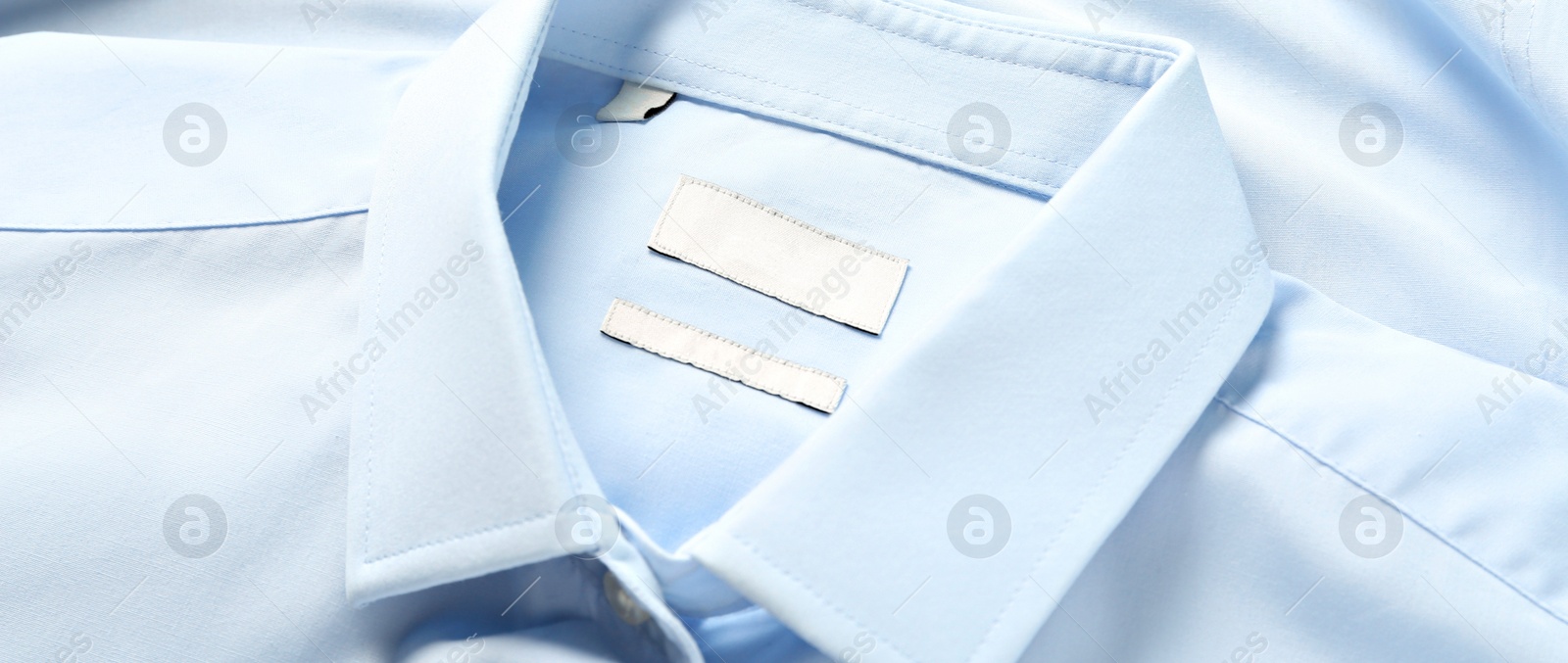 Image of Blank clothing labels on light blue shirt, closeup. Banner design