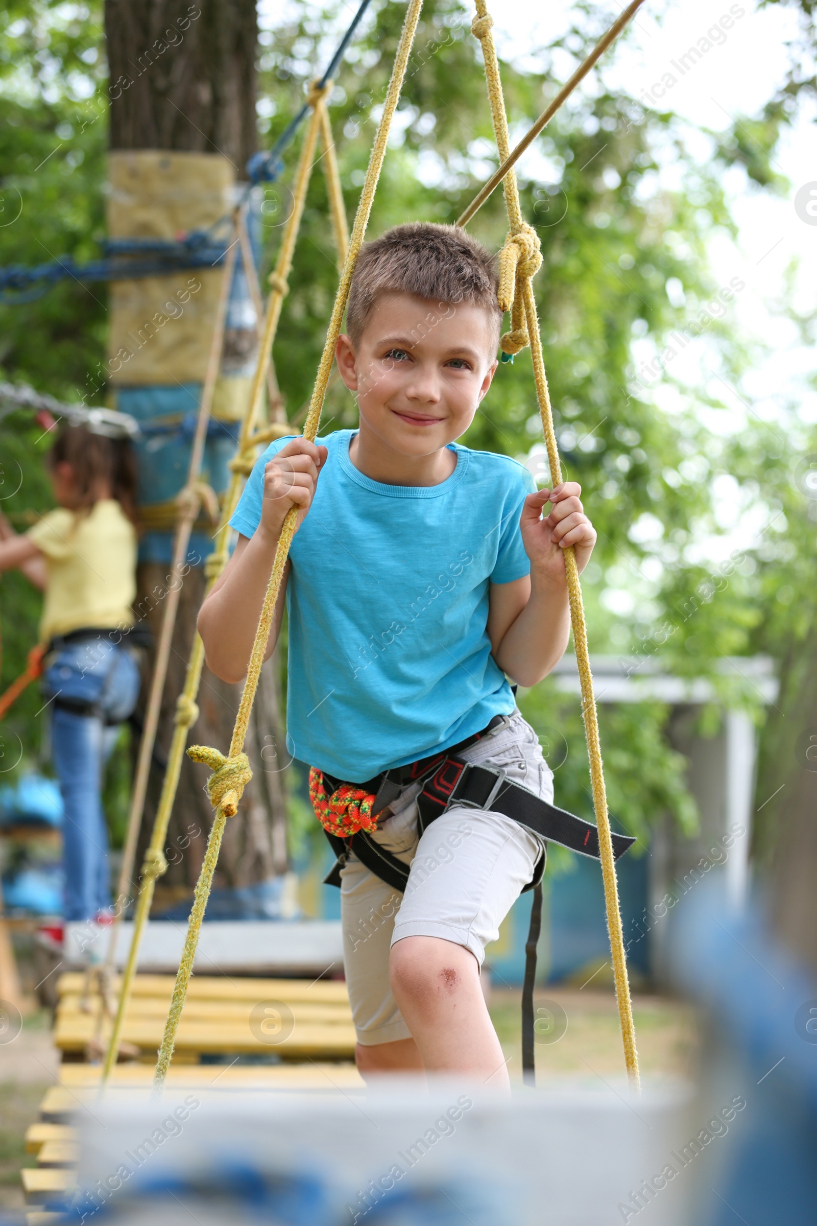 Photo of Little boy climbing in adventure park. Summer camp