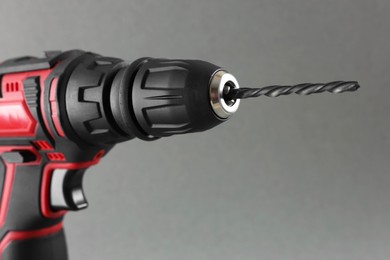 Photo of Modern electric screwdriver on grey background, closeup