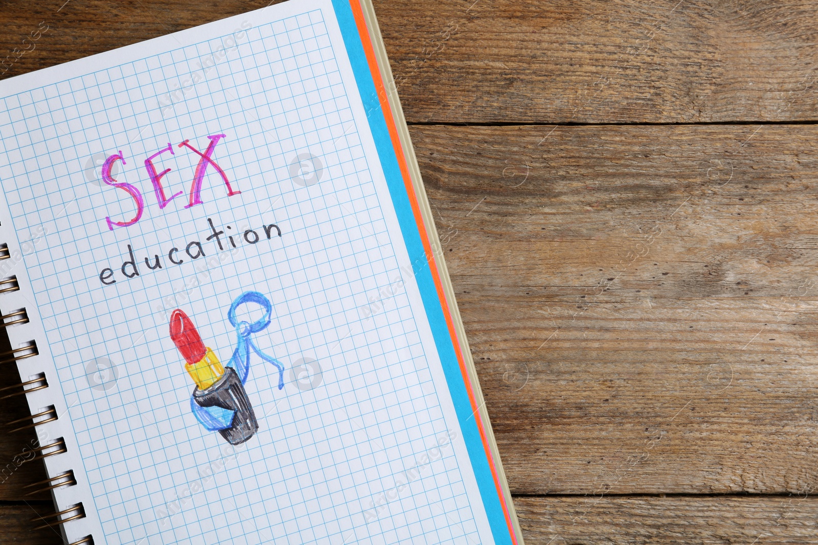 Photo of Notebook with phrase "SEX EDUCATION" on wooden background, top view. Space for text