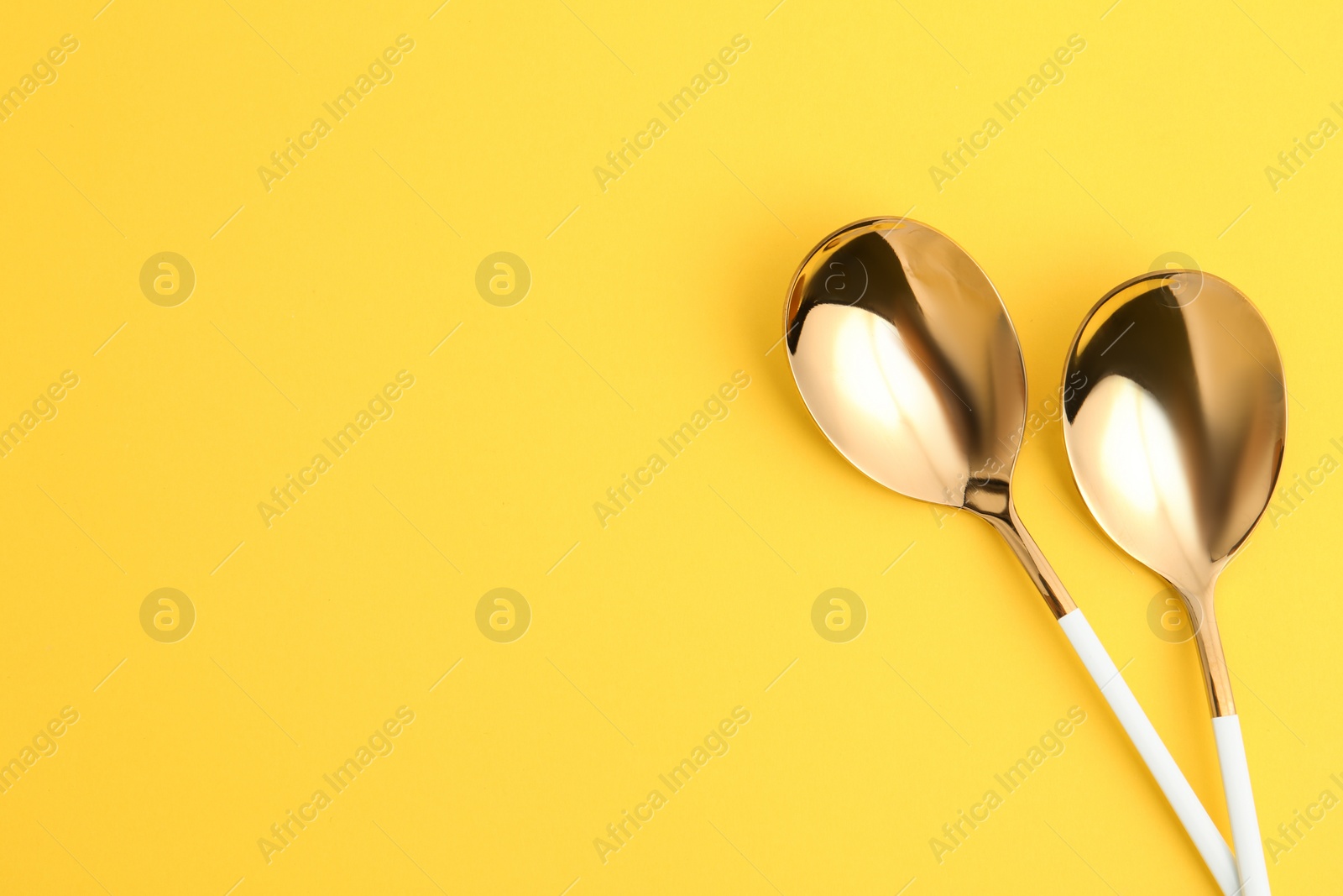 Photo of Clean tablespoons and space for text on color background, flat lay