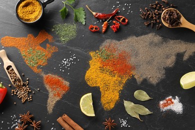 Photo of World map of different spices and products on dark textured table, flat lay