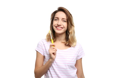 Portrait of young woman with toothbrush on white background