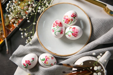 Photo of Flat lay composition with painted Easter eggs on dark table