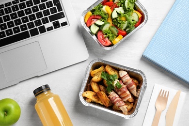 Photo of Composition with lunchboxes and laptop on white wooden table, flat lay. Healthy food delivery