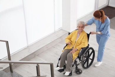 Nurse assisting senior woman in wheelchair at hospital