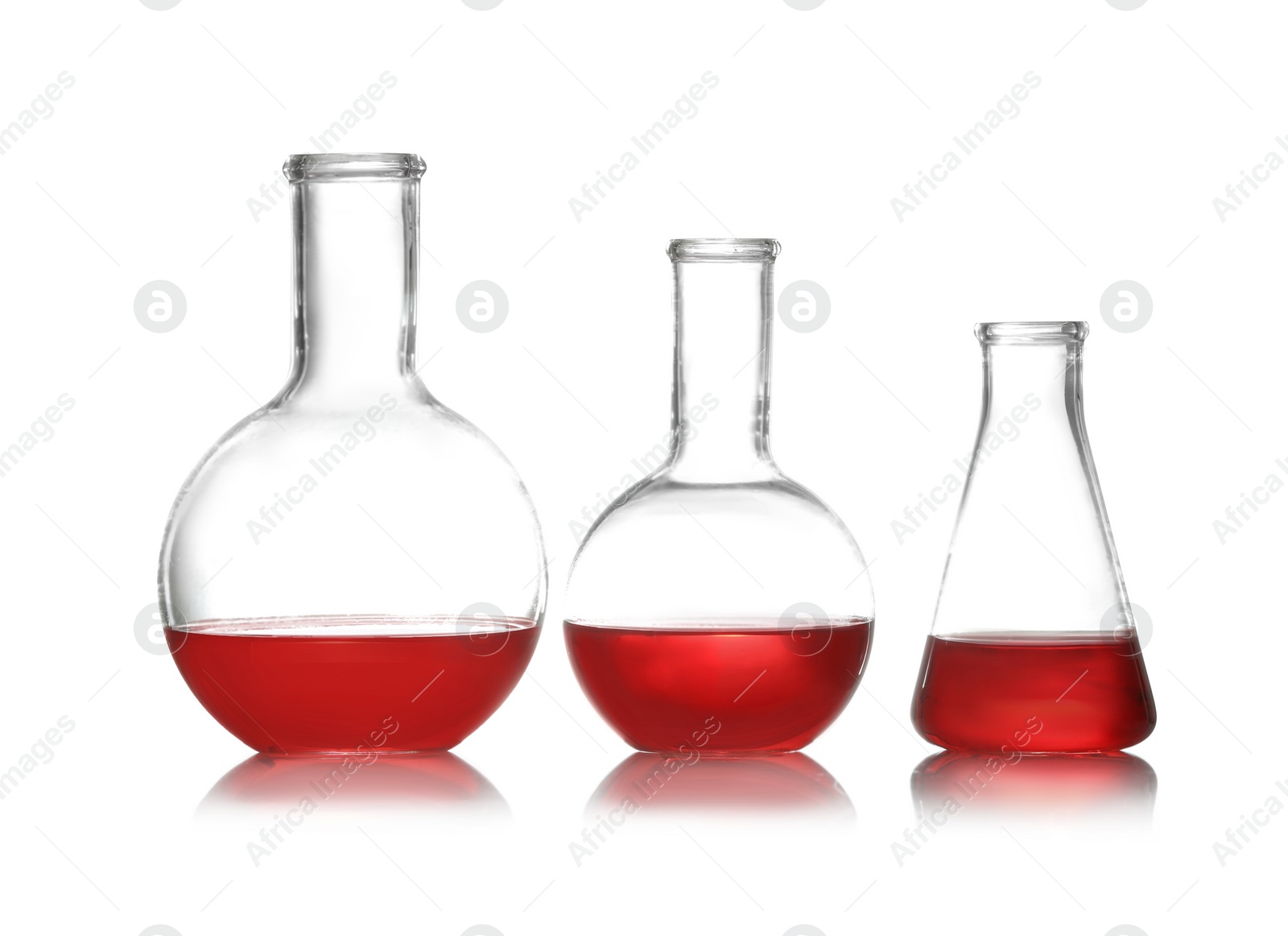 Photo of Group of chemistry glassware with liquid samples isolated on white