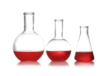 Group of chemistry glassware with liquid samples isolated on white