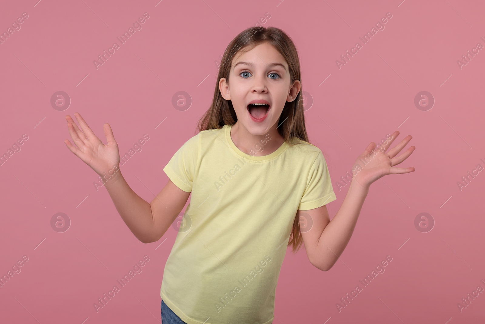 Photo of Portrait of surprised girl on pink background