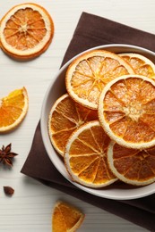 Many dry orange slices and spices on white wooden table, flat lay