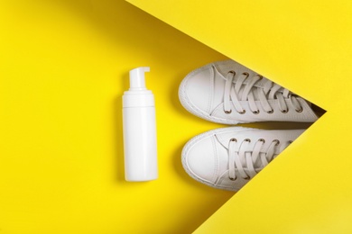Photo of Stylish footwear and shoe care accessory on yellow background, flat lay