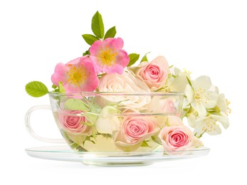 Photo of Aromatic herbal tea in glass cup with different flowers isolated on white