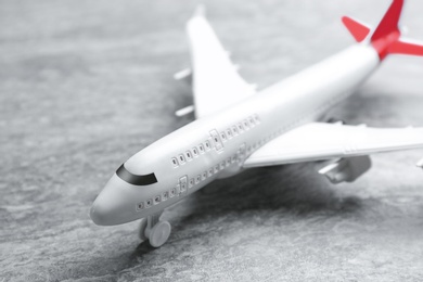 Photo of Toy airplane on grey stone background, closeup