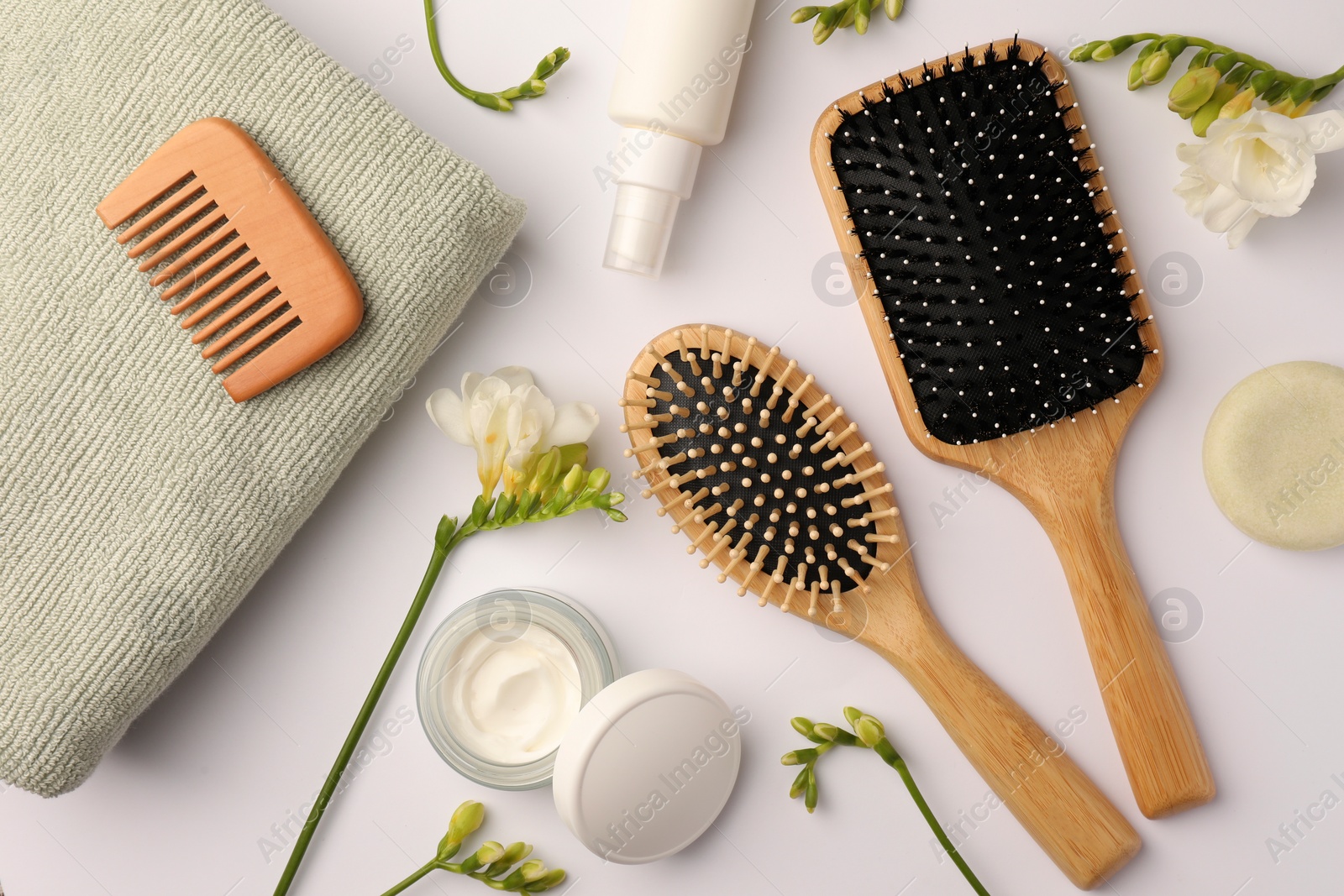 Photo of Flat lay composition with wooden hairbrushes and different cosmetic products on white background