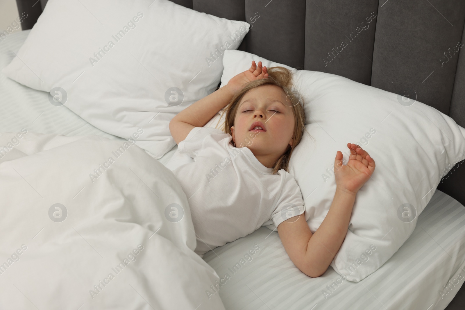 Photo of Little girl snoring while sleeping in bed